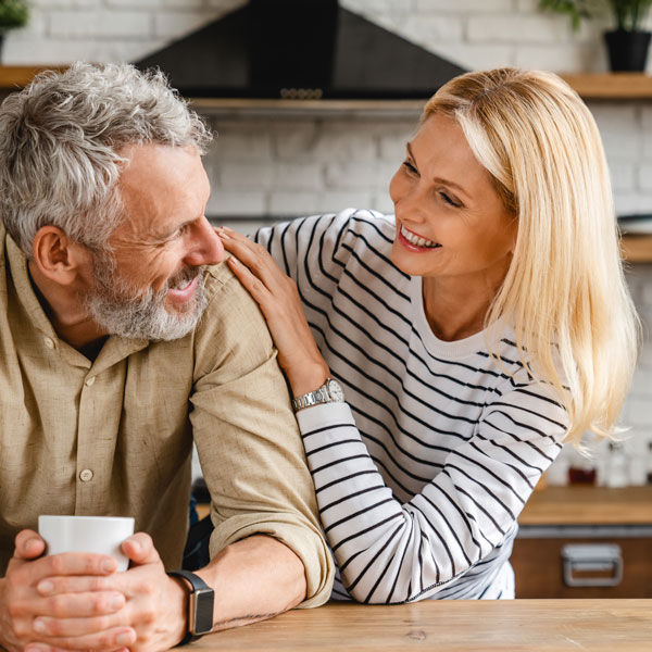 mature man and woman smiling in kitchen